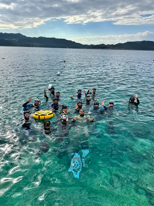 Festival participants waving in the clear water at the training site in Kaş