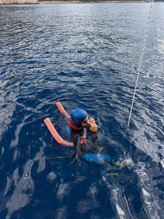A freediver preparing at the buoy before a dive